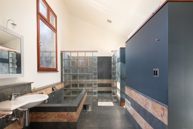 bathroom with high vaulted ceiling, sink, and tile walls