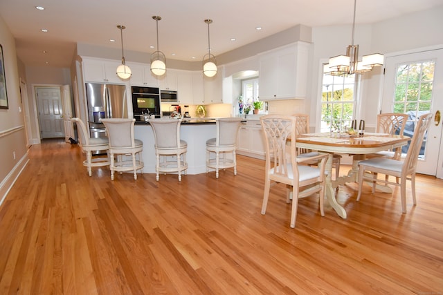 dining area featuring light hardwood / wood-style floors and a notable chandelier