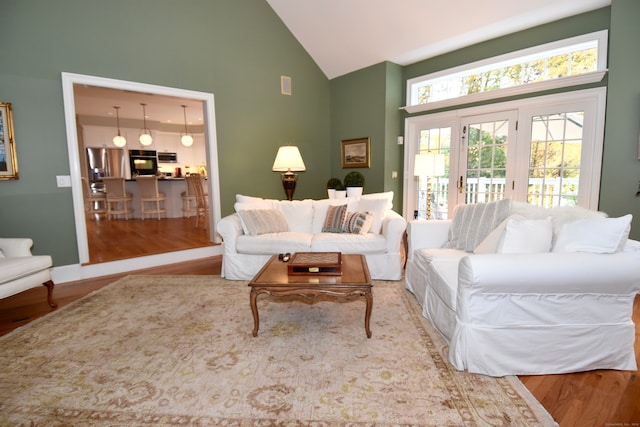 living room featuring high vaulted ceiling and hardwood / wood-style flooring