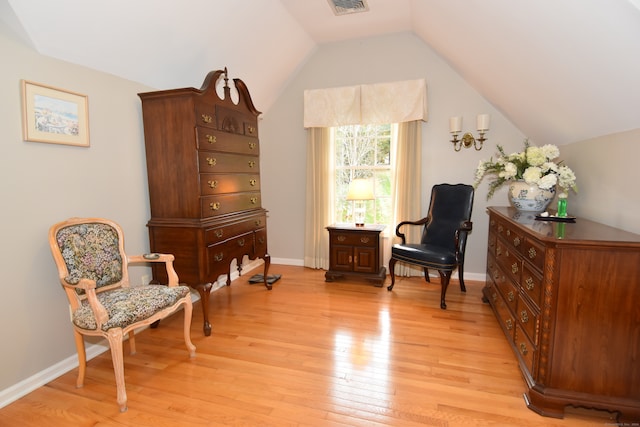 sitting room with light hardwood / wood-style floors and vaulted ceiling