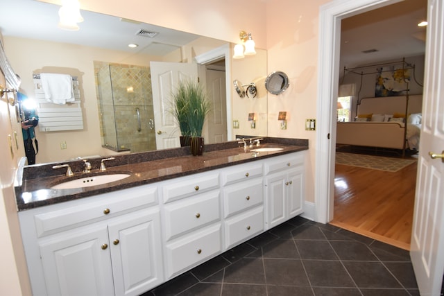 bathroom featuring wood-type flooring, a shower with shower door, and vanity