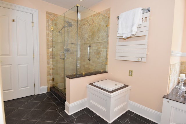 bathroom with a shower with shower door, tile patterned flooring, and radiator heating unit