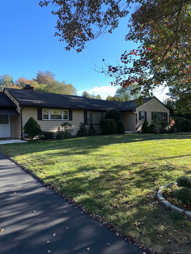 ranch-style home with a garage and a front lawn