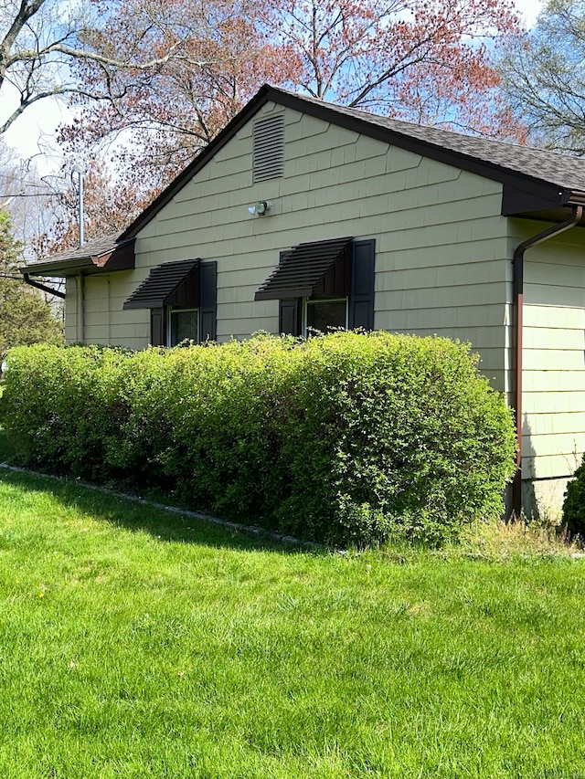 view of side of home with a lawn