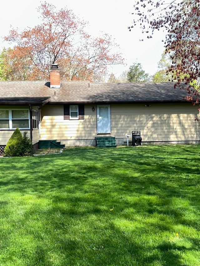 rear view of property with a lawn