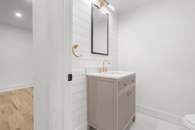 bathroom with vanity, toilet, and wood-type flooring