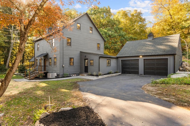 view of front of property featuring central AC, an outbuilding, and a garage