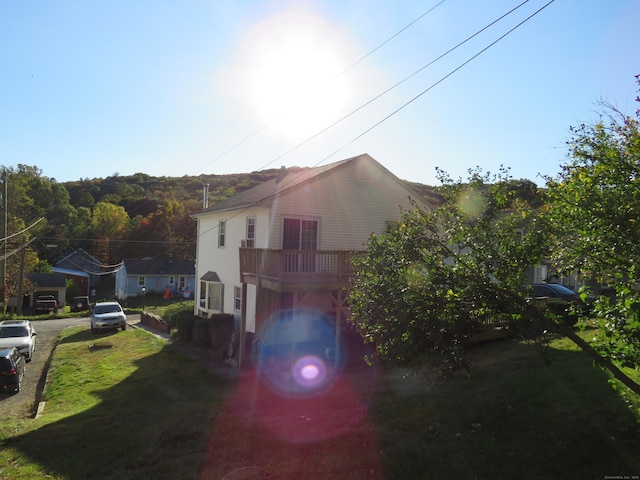 view of property exterior featuring a lawn and a deck