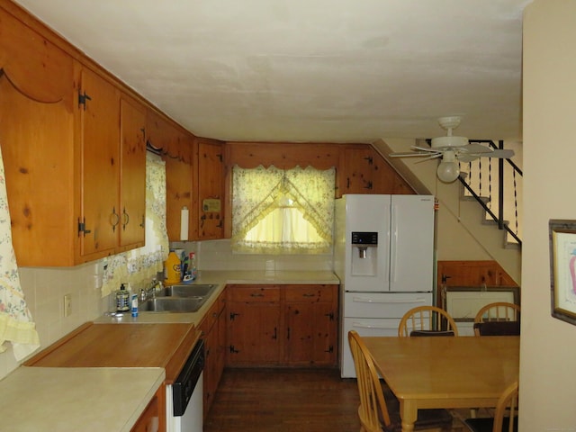 kitchen with sink, white appliances, dark wood-type flooring, and tasteful backsplash