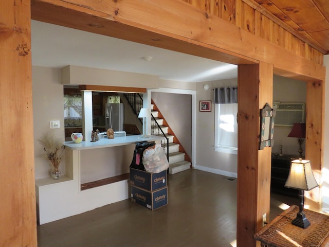 interior space featuring stainless steel fridge with ice dispenser, dark hardwood / wood-style flooring, and an AC wall unit