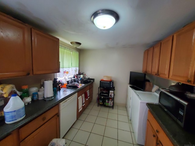 kitchen with dishwasher, sink, independent washer and dryer, and light tile patterned flooring