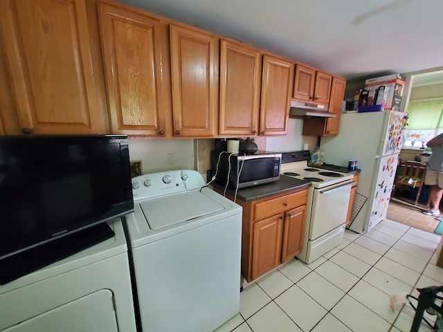 kitchen with independent washer and dryer, white appliances, and light tile patterned floors