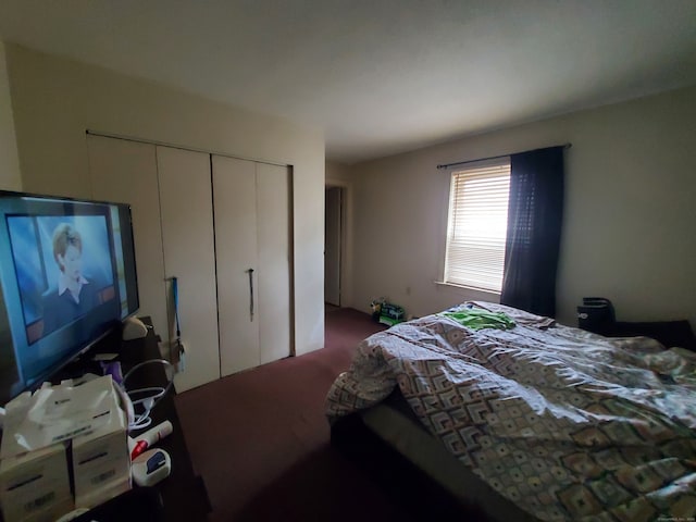 bedroom with a closet and dark carpet