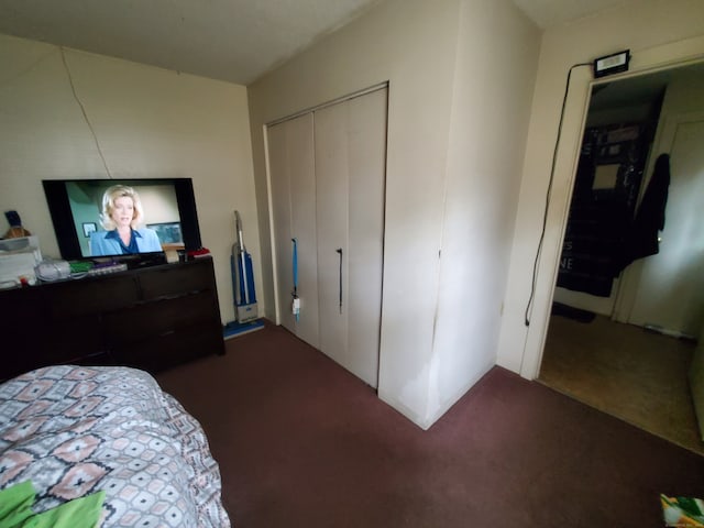 bedroom with a closet and dark carpet