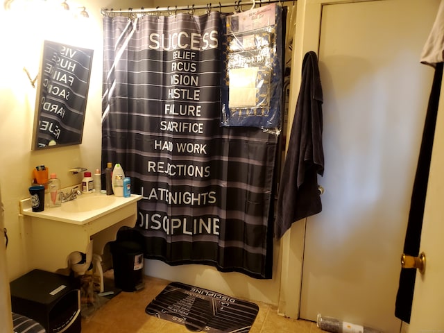 bathroom featuring tile patterned flooring, curtained shower, and sink