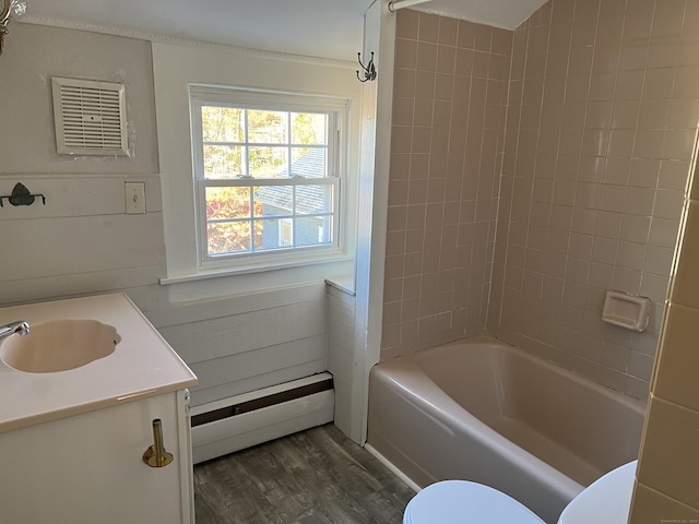 full bath featuring toilet, wood finished floors, bathtub / shower combination, baseboard heating, and vanity