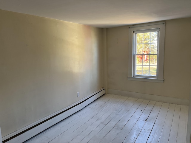 empty room featuring baseboard heating and wood finished floors