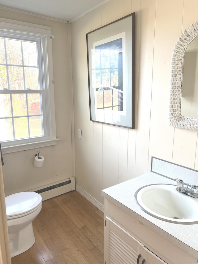 bathroom with a baseboard radiator, vanity, toilet, and wood finished floors