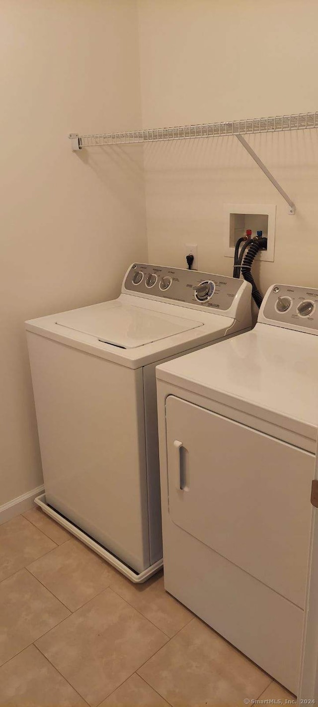 laundry room featuring independent washer and dryer and light tile patterned flooring