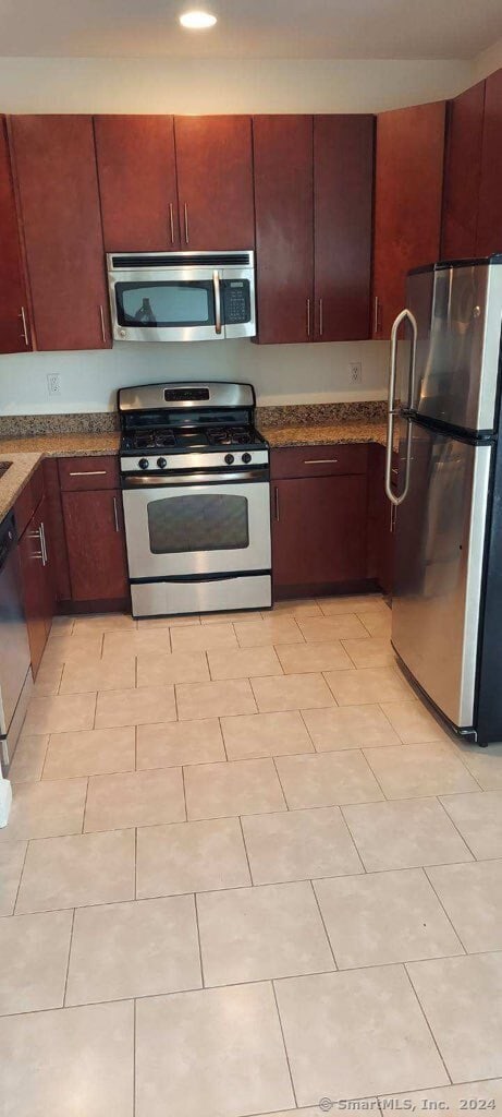 kitchen featuring dark stone countertops and stainless steel appliances