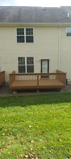 back of house featuring a wooden deck and a lawn