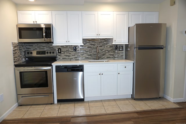 kitchen with white cabinetry, light hardwood / wood-style floors, stainless steel appliances, and sink