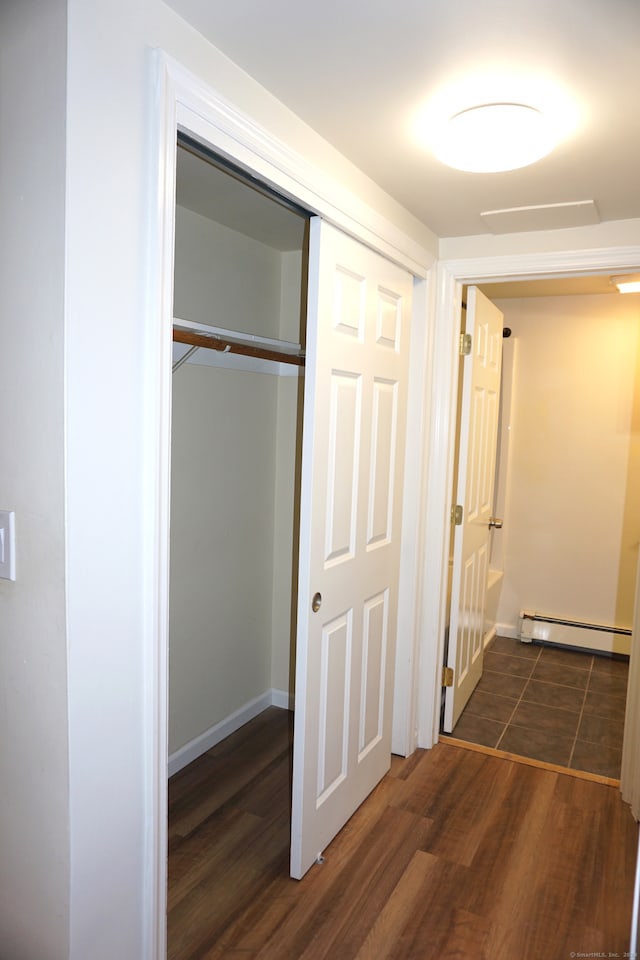 corridor featuring baseboard heating and dark wood-type flooring