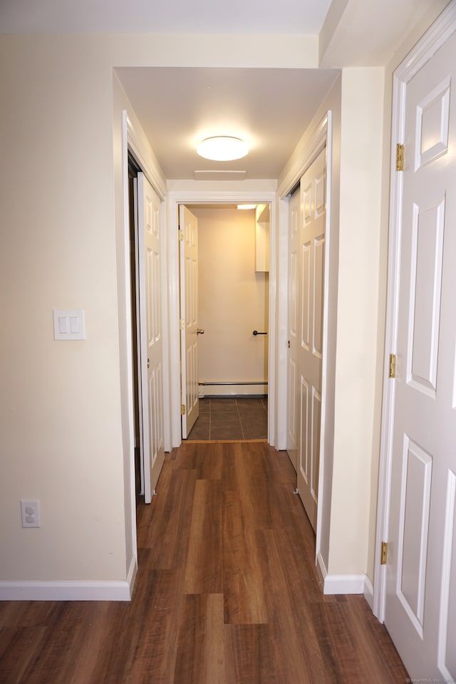 hall featuring a baseboard radiator and dark hardwood / wood-style flooring