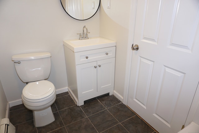 bathroom with toilet, a baseboard heating unit, vanity, and tile patterned floors