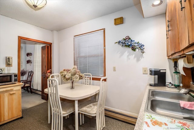 carpeted dining area featuring sink and a baseboard radiator