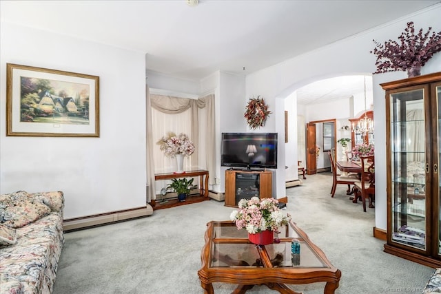 carpeted living room featuring ornamental molding, a baseboard heating unit, and an inviting chandelier