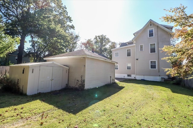 back of property featuring a storage unit and a lawn