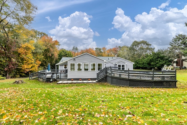 back of property with a yard and a deck