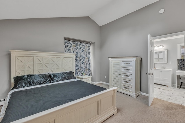 bedroom with light carpet, ensuite bathroom, a sink, baseboards, and vaulted ceiling