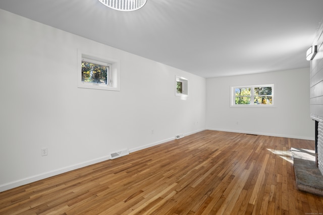 unfurnished living room with a brick fireplace and hardwood / wood-style floors