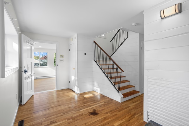 interior space with a baseboard radiator and hardwood / wood-style flooring