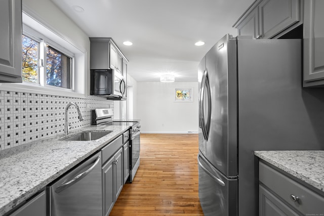 kitchen featuring gray cabinetry, appliances with stainless steel finishes, sink, and light wood-type flooring