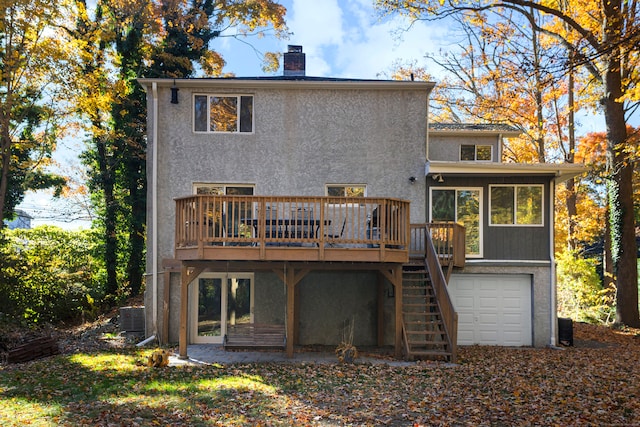 back of property featuring a wooden deck, a garage, and central AC unit