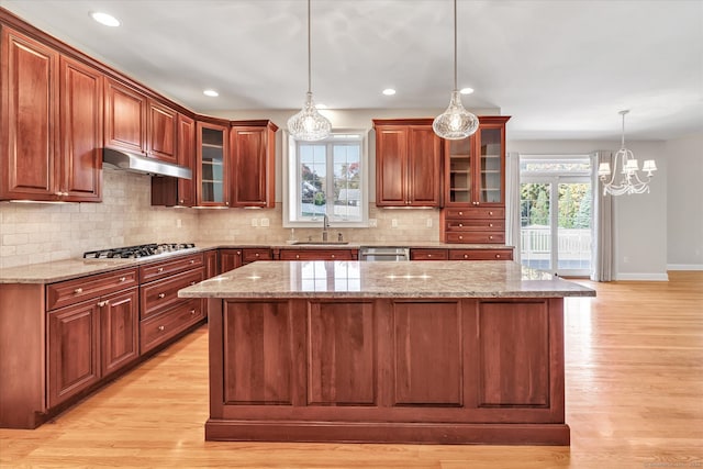 kitchen featuring sink, hanging light fixtures, plenty of natural light, and light wood-type flooring