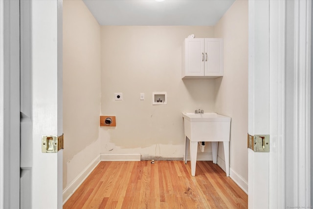 washroom with hookup for an electric dryer, hookup for a washing machine, light hardwood / wood-style floors, and cabinets