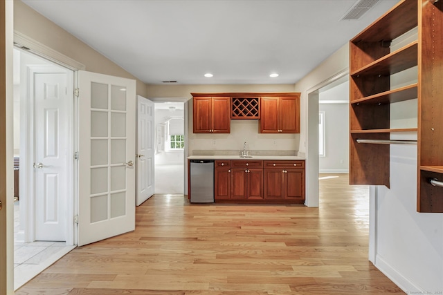 kitchen with sink, dishwasher, and light hardwood / wood-style floors