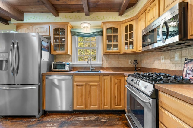 kitchen featuring beam ceiling, tasteful backsplash, appliances with stainless steel finishes, dark wood-type flooring, and sink