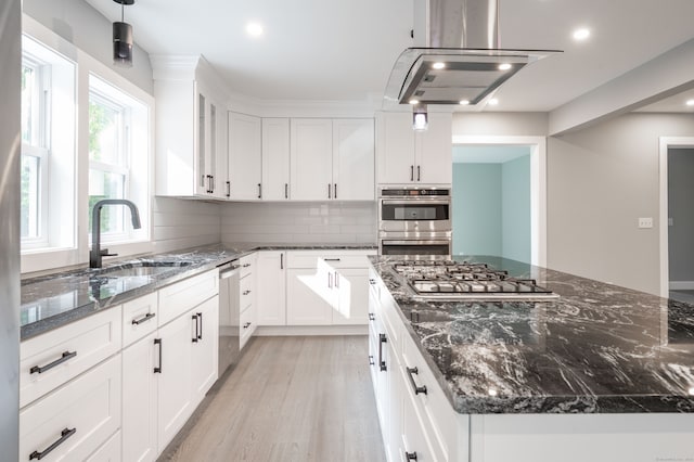 kitchen with island exhaust hood, white cabinets, light hardwood / wood-style flooring, stainless steel appliances, and sink