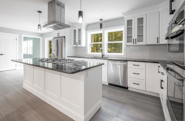 kitchen featuring white cabinets, appliances with stainless steel finishes, a kitchen island, and island range hood