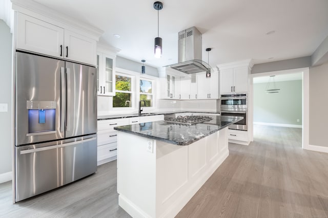 kitchen with appliances with stainless steel finishes, light wood-type flooring, island range hood, white cabinetry, and dark stone countertops