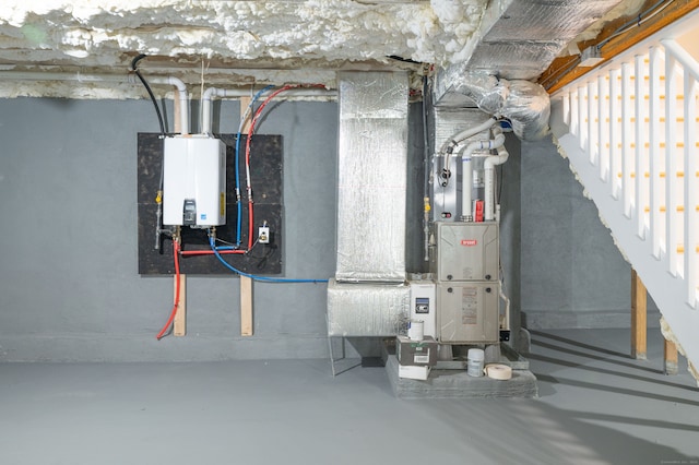 utility room with tankless water heater and heating unit