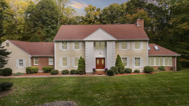 colonial inspired home featuring a lawn