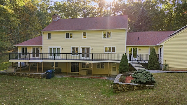 rear view of house with a wooden deck, a patio area, and a yard