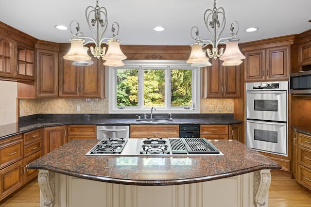 kitchen with pendant lighting, stainless steel appliances, a notable chandelier, and sink