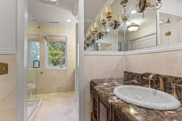 bathroom with vanity, walk in shower, ornamental molding, and tile walls